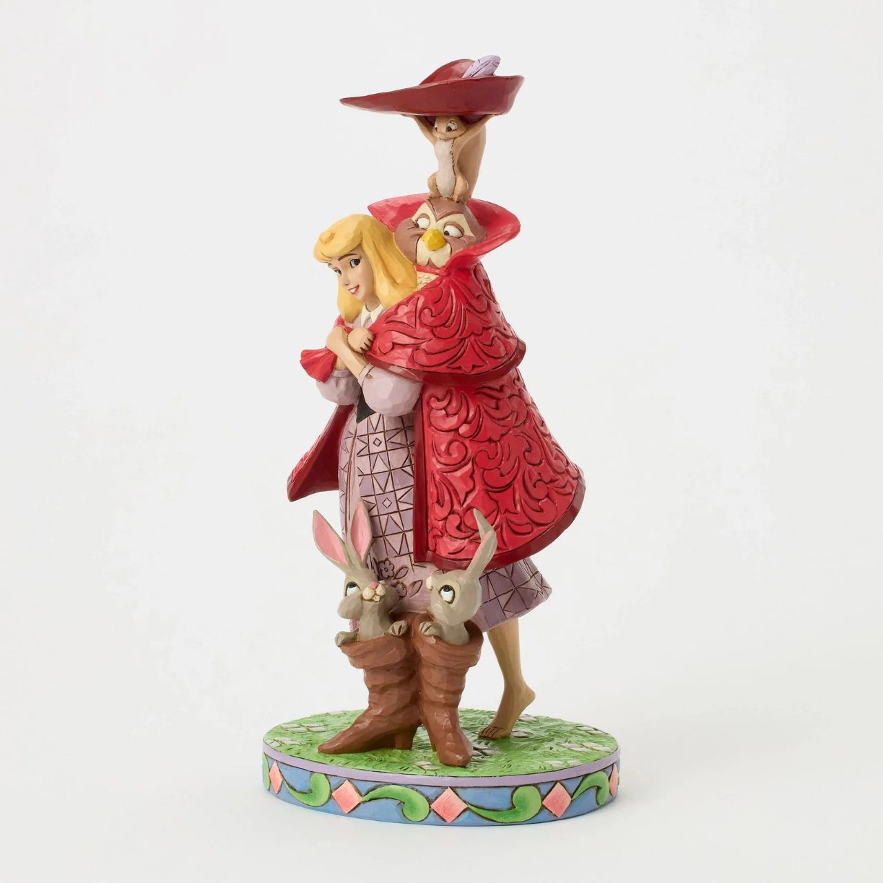 Aurora's forest friends transform into a man in a red coat as she searches for her prince. An owl, squirrel, and bunnies inside boots add charm to this captivating Jim Shore design, bringing the memorable movie scene to life with enchantment.