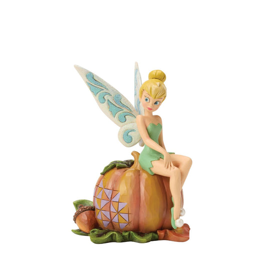 Tinker Bell adds a touch of pixie dust to Halloween magic in this charming Jim Shore design. Dressed in festive autumn colours, she sits gracefully on a pumpkin, blending Disney whimsy with folk-art charm.