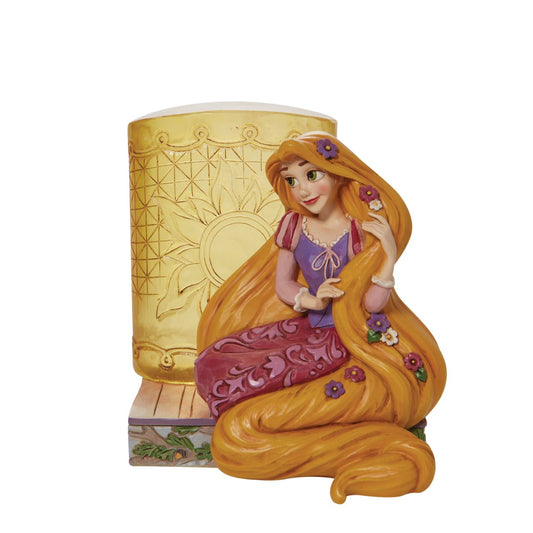 This Disney Traditions line by Jim Shore features iconic Walt Disney princesses with their famous props. With flowers in her long hair, this piece features Rapunzel with her golden locks kneeling next to a large lantern.
