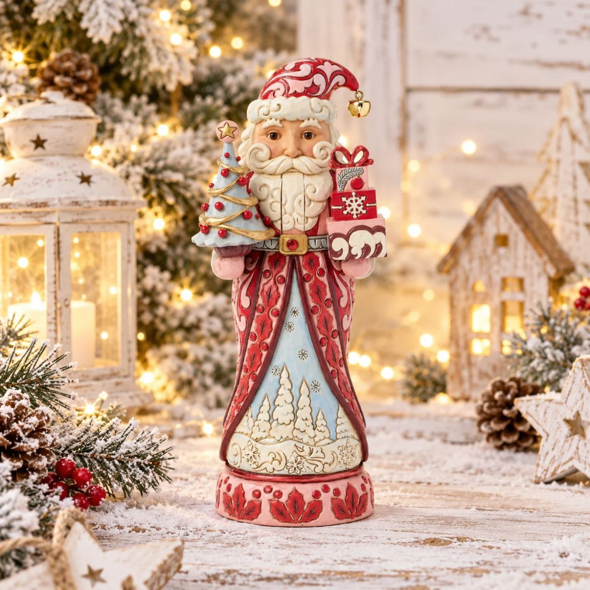 Santa stands tall in pink and crimson coat with snowy trim, his beard curling in carved detail. Folk-art rosemaling swirls across his suit, hand-painted in Jim Shore's warm, festive style.