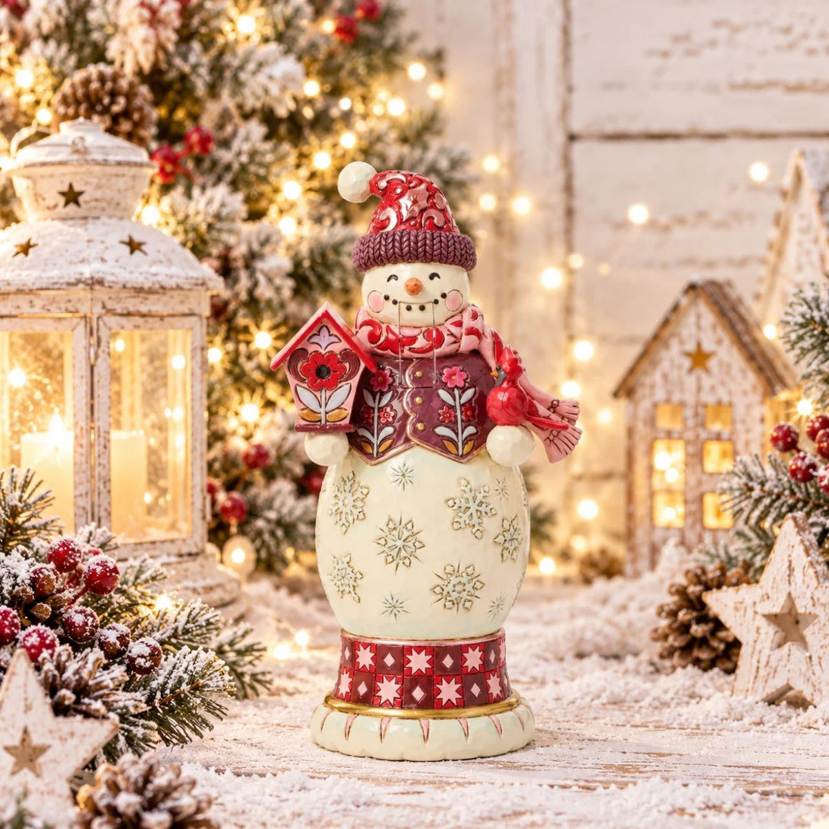 This snowman nutcracker is full of frosty personality, sporting a red top hat, cosy scarf, and cheery smile. Jim Shore's hand-painted folk designs wrap around his coat, adding rich detail and whimsy. A delightful way to bring snowy sparkle indoors.