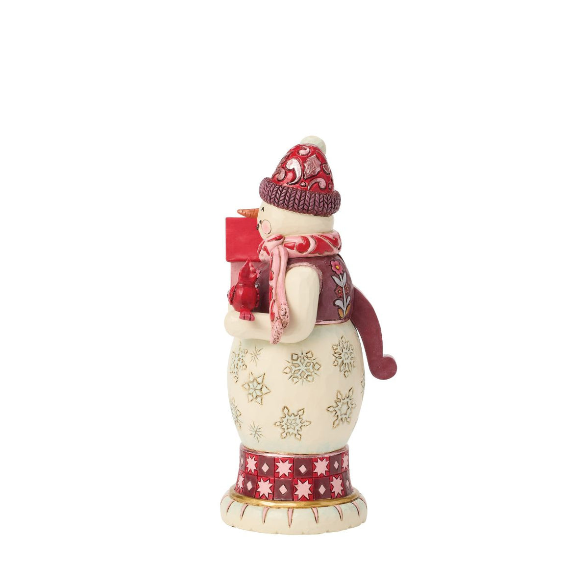 This snowman nutcracker is full of frosty personality, sporting a red top hat, cosy scarf, and cheery smile. Jim Shore's hand-painted folk designs wrap around his coat, adding rich detail and whimsy. A delightful way to bring snowy sparkle indoors.