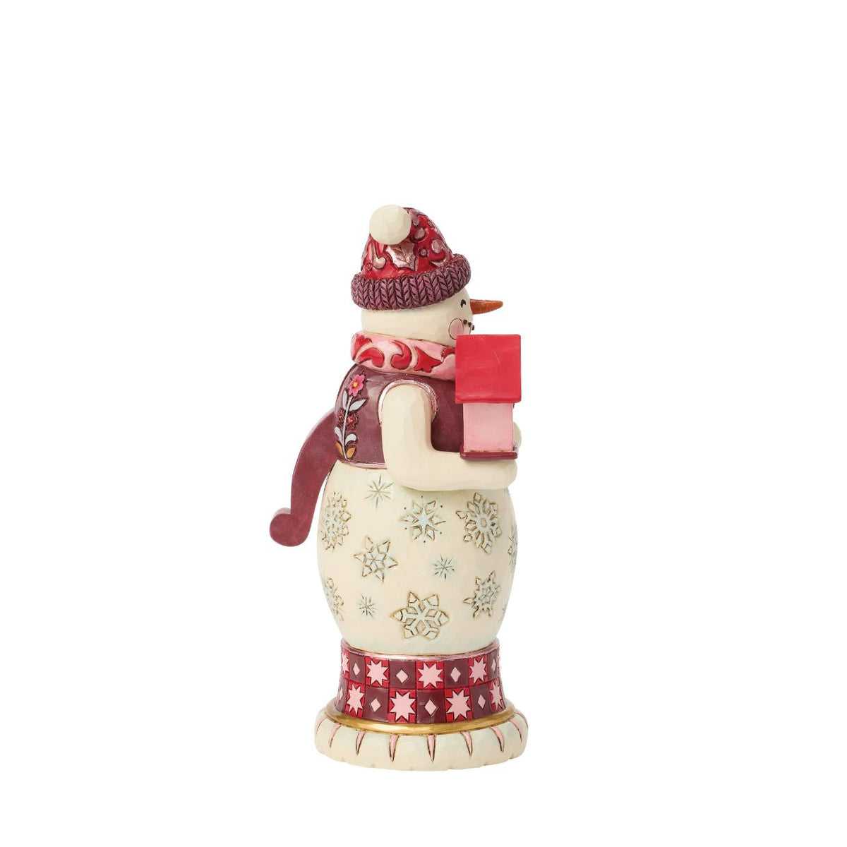This snowman nutcracker is full of frosty personality, sporting a red top hat, cosy scarf, and cheery smile. Jim Shore's hand-painted folk designs wrap around his coat, adding rich detail and whimsy. A delightful way to bring snowy sparkle indoors.