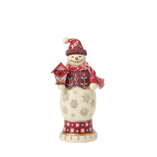 This snowman nutcracker is full of frosty personality, sporting a red top hat, cosy scarf, and cheery smile. Jim Shore's hand-painted folk designs wrap around his coat, adding rich detail and whimsy. A delightful way to bring snowy sparkle indoors.