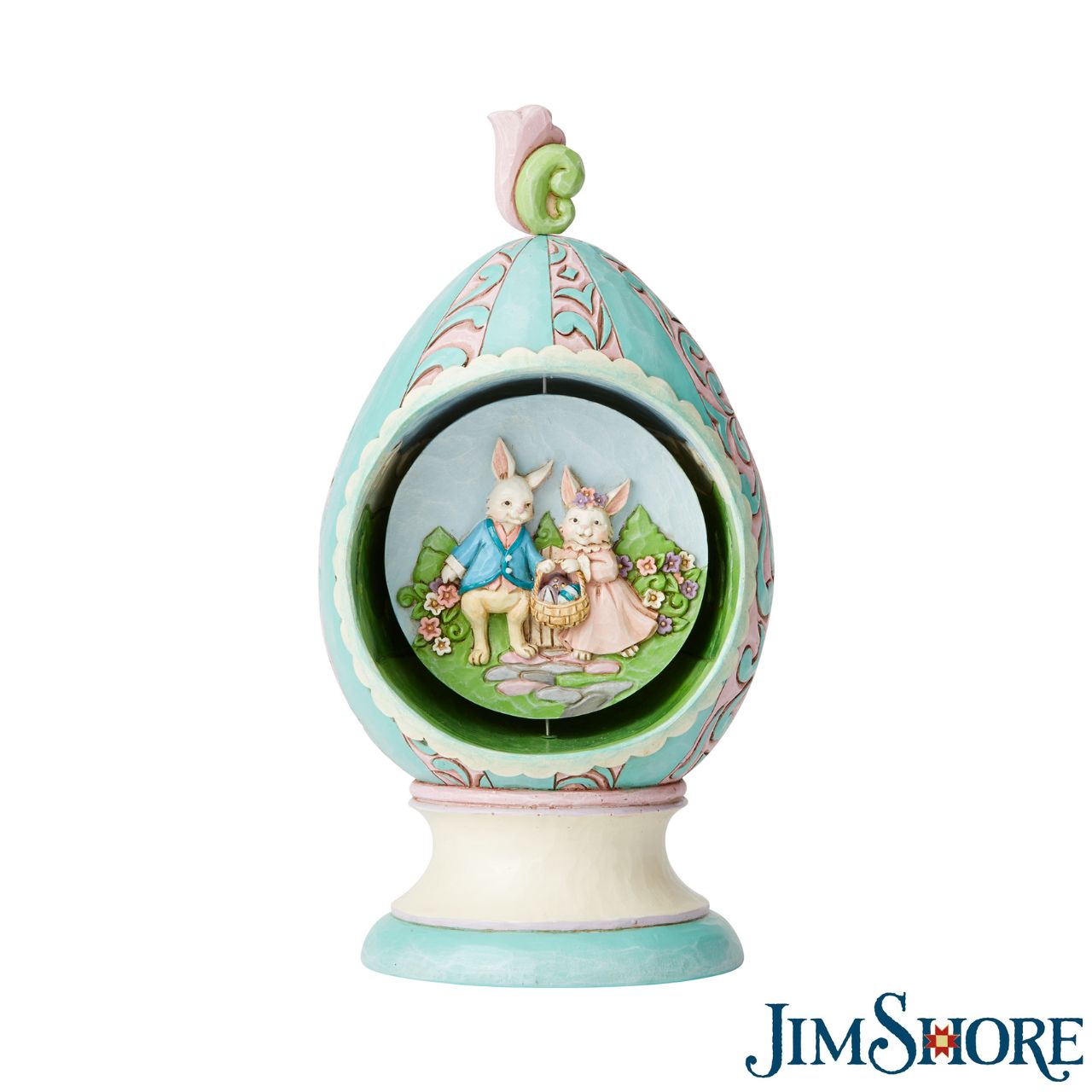 Revolving Egg with Bunnies and Chicks Scene Figurine by Jim Shore  Stroll through Spring with this festive Jim Shore tabletop Easter egg. Simply turn the floral finial atop the egg to rotate the scene inside between two adorable Easter scenes. Chicks soak in the sun while a pair of bunnies jubilantly collect eggs.