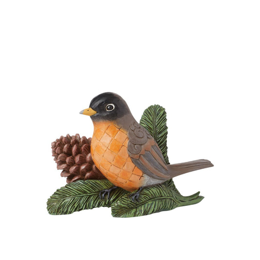 Experience nature's beauty with this striking Jim Shore piece of a serene Robin perched on a pine twig beside a pinecone. Adorned with chequered patterning on its belly and intricate rosemaling on its wing, it captures avian grace in stunning detail.