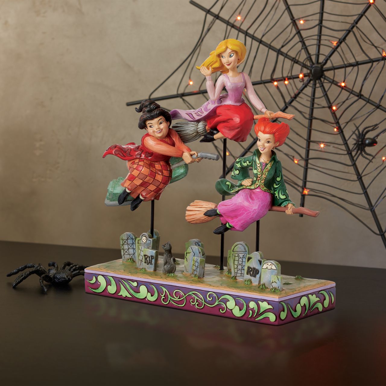 In this spellbinding Jim Shore design, the Sanderson Sisters soar on their broomsticks high above a moonlit Salem, Massachusetts. Each sister wears her iconic gown, with an expression perfectly capturing their distinct and hilarious personalities.