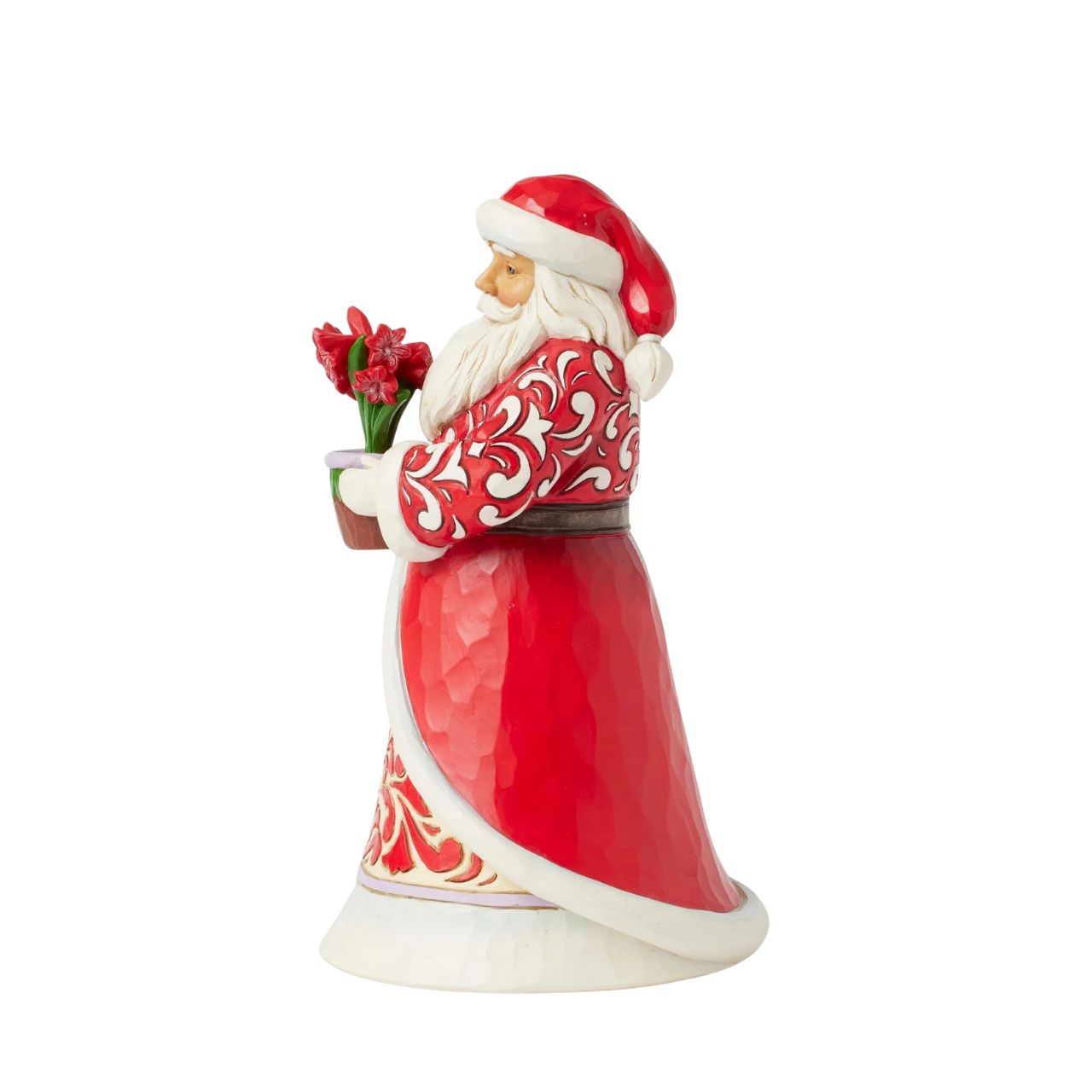 With a peaceful smile, this Jim Shore Santa holds a vase of vibrant amaryllis flowers, symbolizing the beauty and resilience of winter. His intricately patterned rosemaling coat adds a timeless touch of serenity to your holiday home décor.