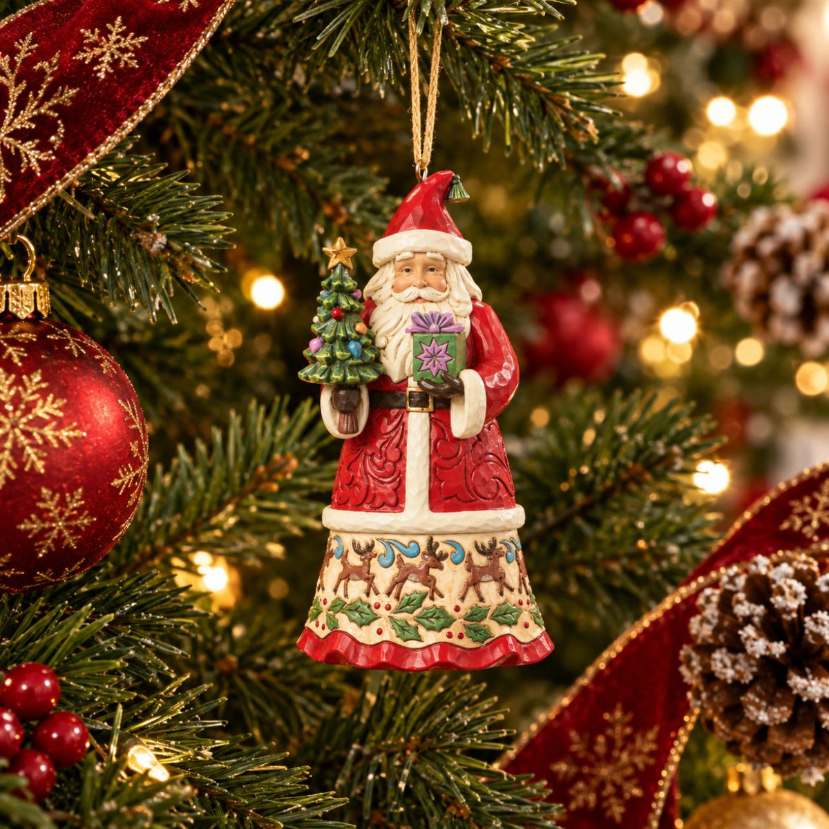 Celebrate the magic of Christmas with this enchanting Santa figurine from Heartwood Creek by Jim Shore. Depicting Santa Claus lovingly holding a variety of colourful gifts, this piece is meticulously crafted with intricate details and folk-art inspired patterns.