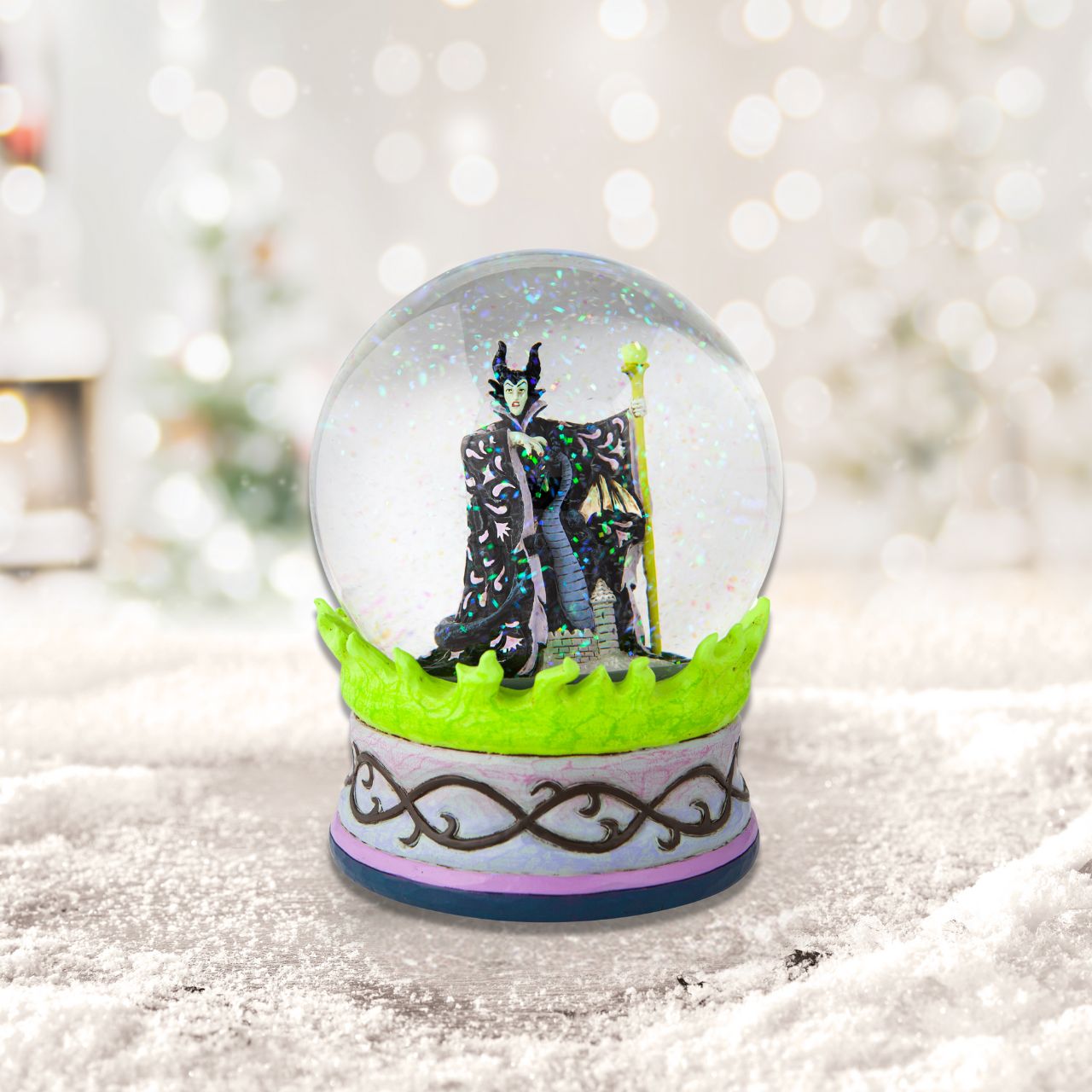 Disney's Sleeping Beauty Maleficent  Christmas Snow Globe  This waterball is almost caldron-like with it's eerie green flames and evil centerpiece. Maleficent, the bitter witch of Disney's Sleeping Beauty, strikes a dubious pose in the water. With immaculate craftsmanship this Jim Shore piece astonishes.