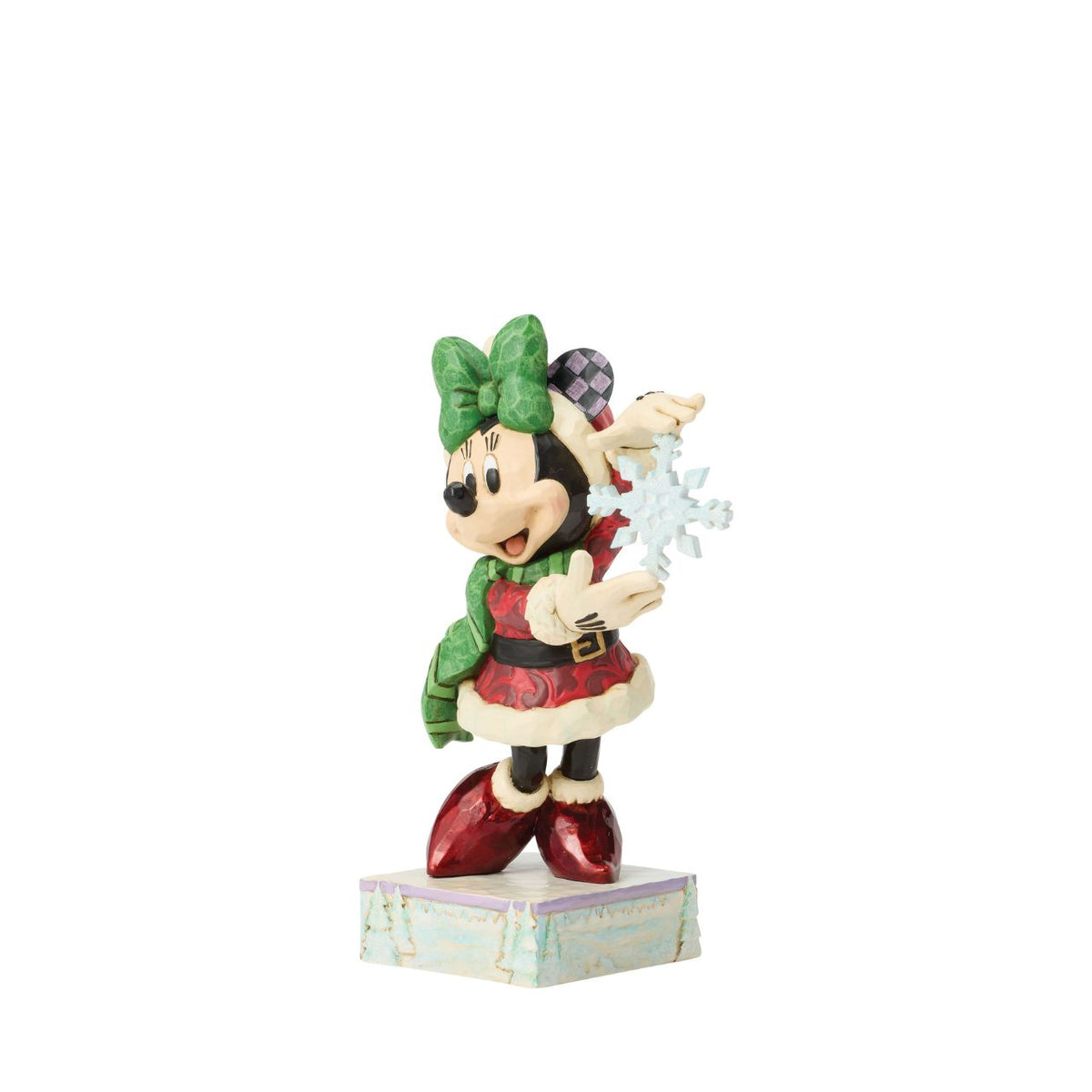 Minnie Mouse sparkles in holiday style as she holds a delicate snowflake in this Jim Shore masterpiece.