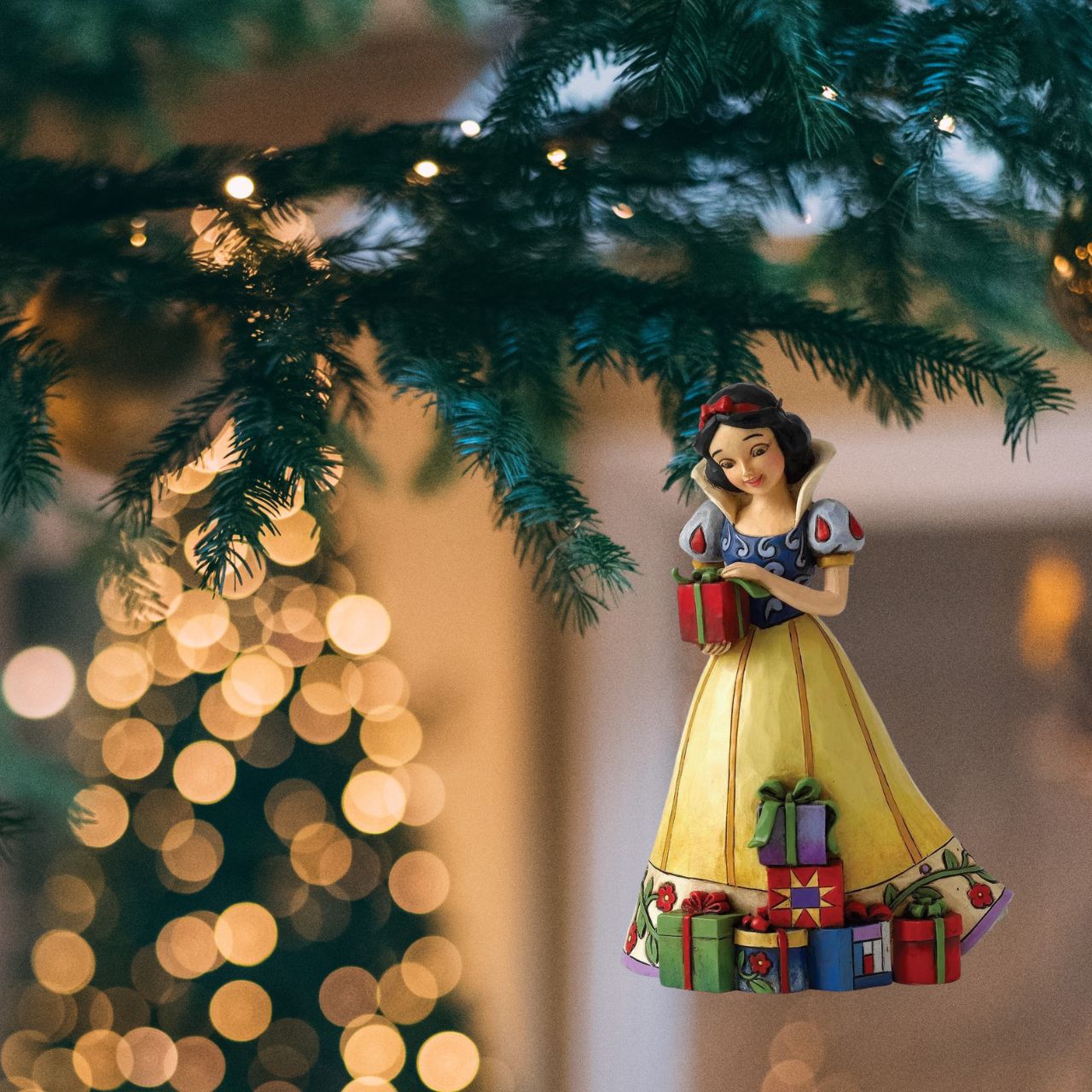 Jim Shore Disney Snow White Hanging Ornament  Disney Traditions combines the magic of Disney with the festive artistry of Jim Shore. This Snow White cast stone hanging ornament is sure to add Disney's magic to your Christmas tree.