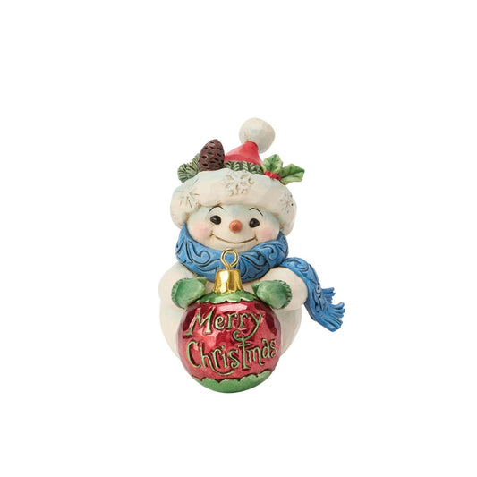 Embrace the enchantment of winter with this delightful miniature snowman figurine from Heartwood Creek by Jim Shore. This endearing snowman holds a large, beautifully detailed ball, showcasing Jim Shore's signature folk-art style.