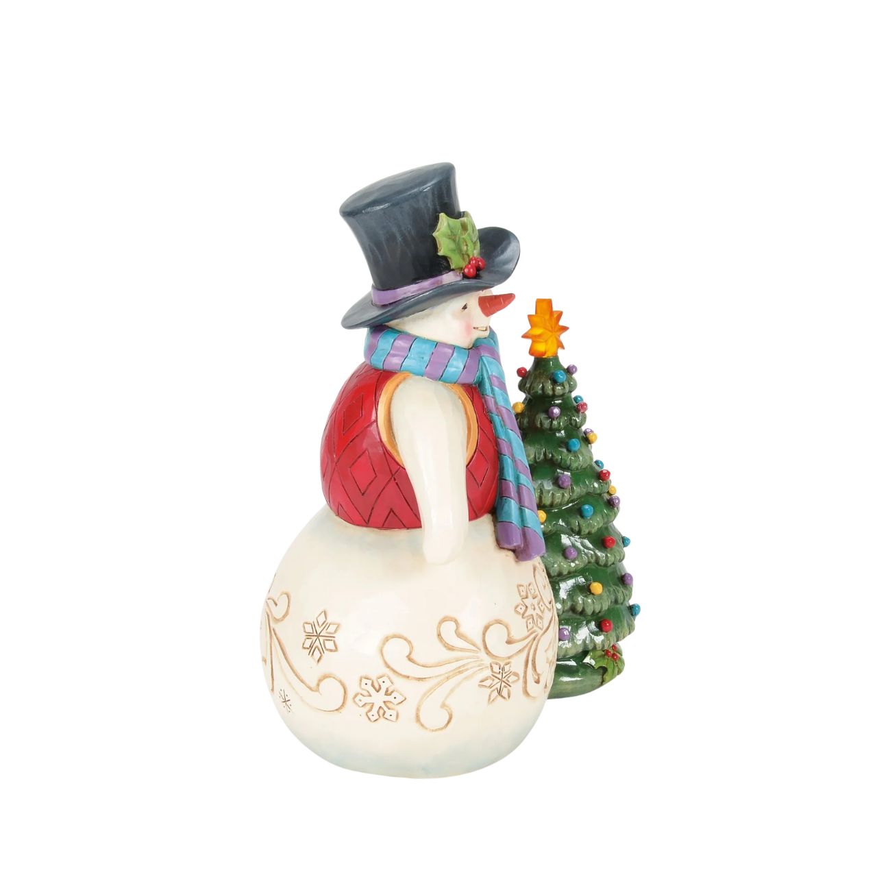 This enchanting Jim Shore snowman, dressed in a gorgeous tunic, scarf, and holly-brimmed top hat, stands beside a decorated Christmas tree and the star lights up. Adorned with snowflakes and rosemaling, he brings a vintage warmth to your holiday home.