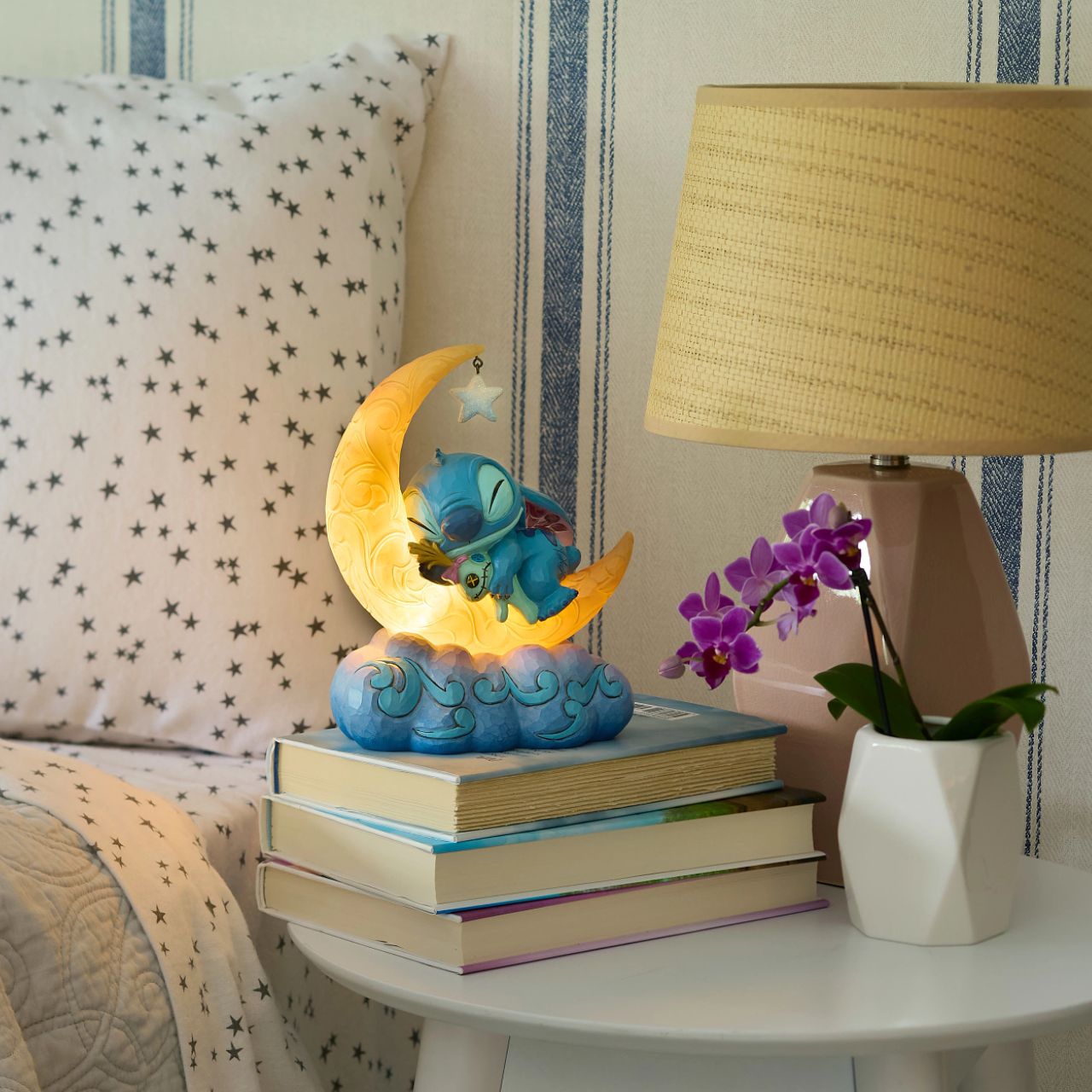 Snuggled up with his plush Scrump, Disney's Stitch is ready for dreamland. Asleep on a crescent moon that glows, this is the perfect addition to any display or bedroom. Requires 3x AAA batteries (not included), uses an automatic timer for 6 hours on, 18 hours off.
