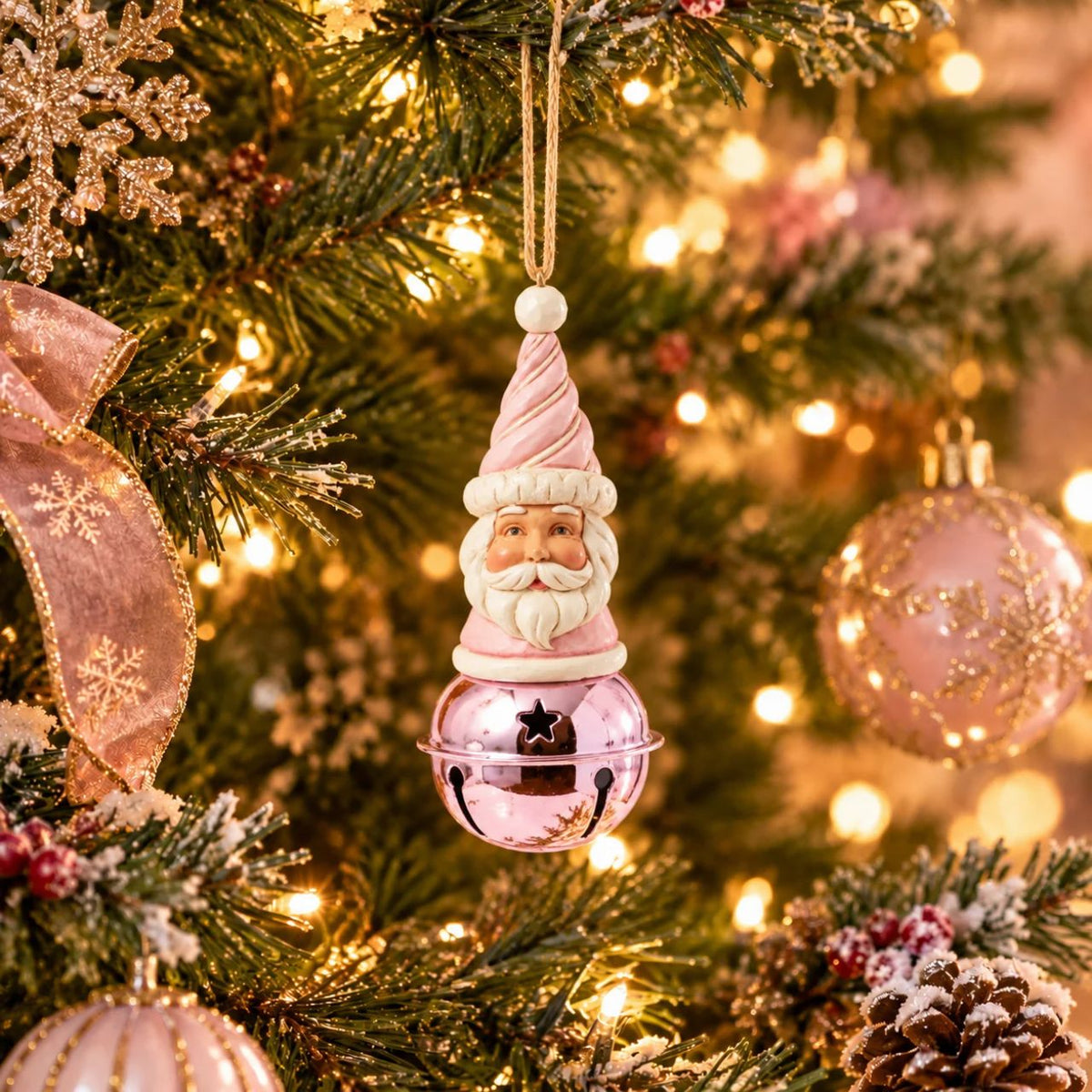 This delightful Jim Shore Heartwood Sweets jingle bell ornament features a charming miniature bust of Santa, complete with a pastel pink icing hat and rosy cheeks that exude holiday cheer. Ring in the season with Jim Shore.