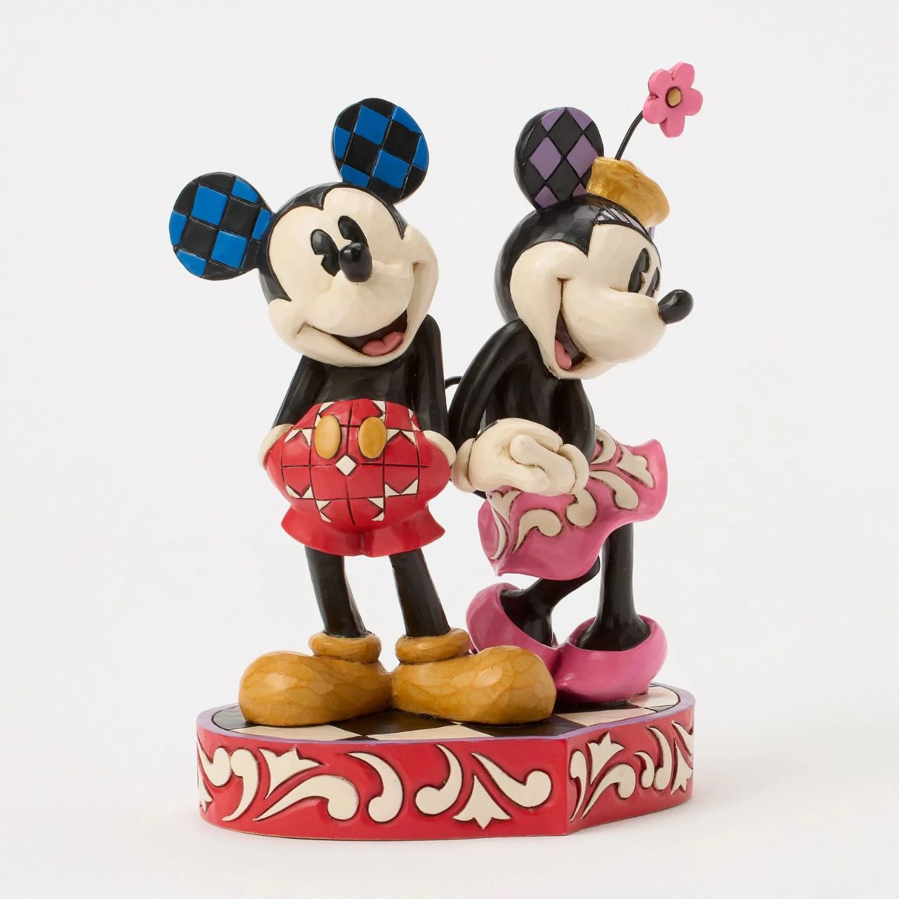 This romantic Disney design by Jim Shore features Mickey and Minnie Mouse, adorned with rosemaling and patchwork details. They stand on a heart-shaped base radiating the warmth of their timeless affection.