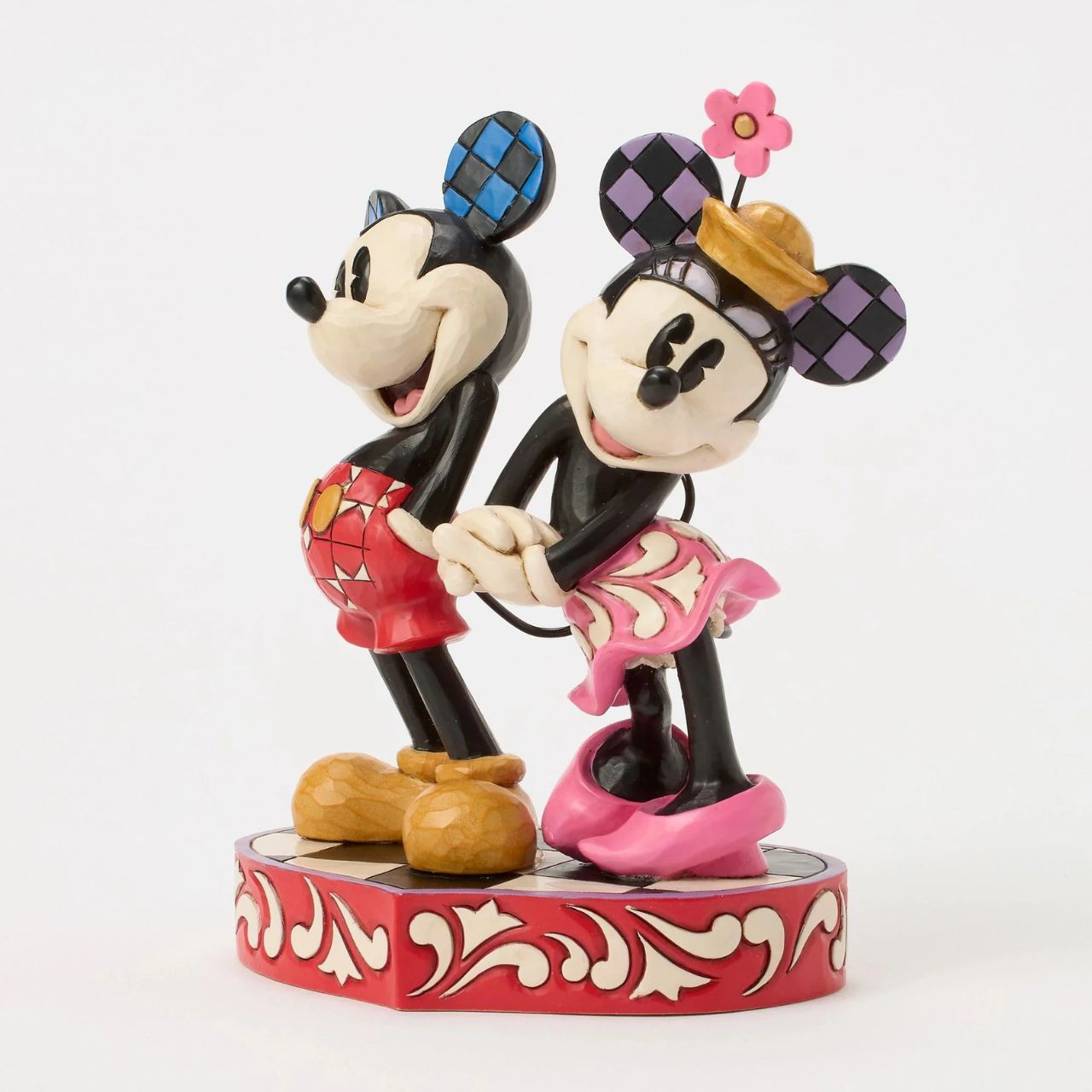 This romantic Disney design by Jim Shore features Mickey and Minnie Mouse, adorned with rosemaling and patchwork details. They stand on a heart-shaped base radiating the warmth of their timeless affection.