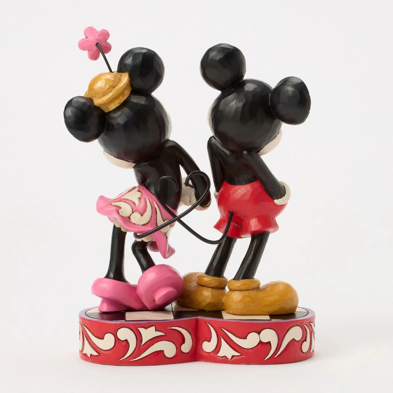 This romantic Disney design by Jim Shore features Mickey and Minnie Mouse, adorned with rosemaling and patchwork details. They stand on a heart-shaped base radiating the warmth of their timeless affection.
