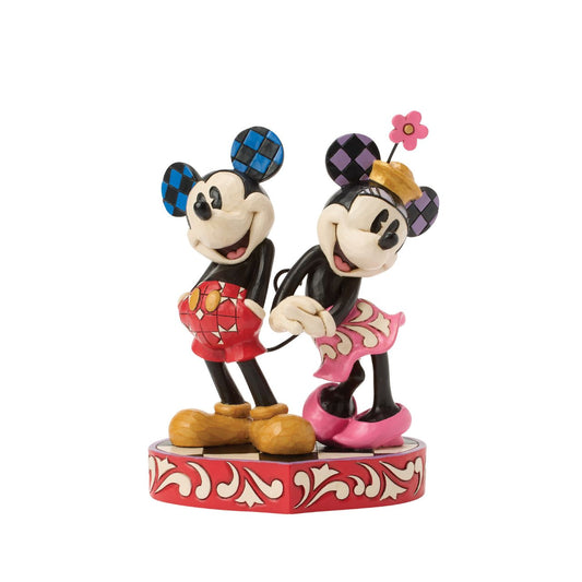 This romantic Disney design by Jim Shore features Mickey and Minnie Mouse, adorned with rosemaling and patchwork details. They stand on a heart-shaped base radiating the warmth of their timeless affection.