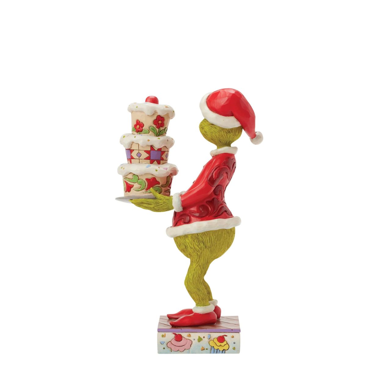 Disguised as Santa, The Grinch beams with trickery as he steals a towering cake. Adorned with Jim Shore's iconic rosemaling, patchwork patterns, and charming floral details, this piece captures the mischief of Christmas in true Grinch fashion.