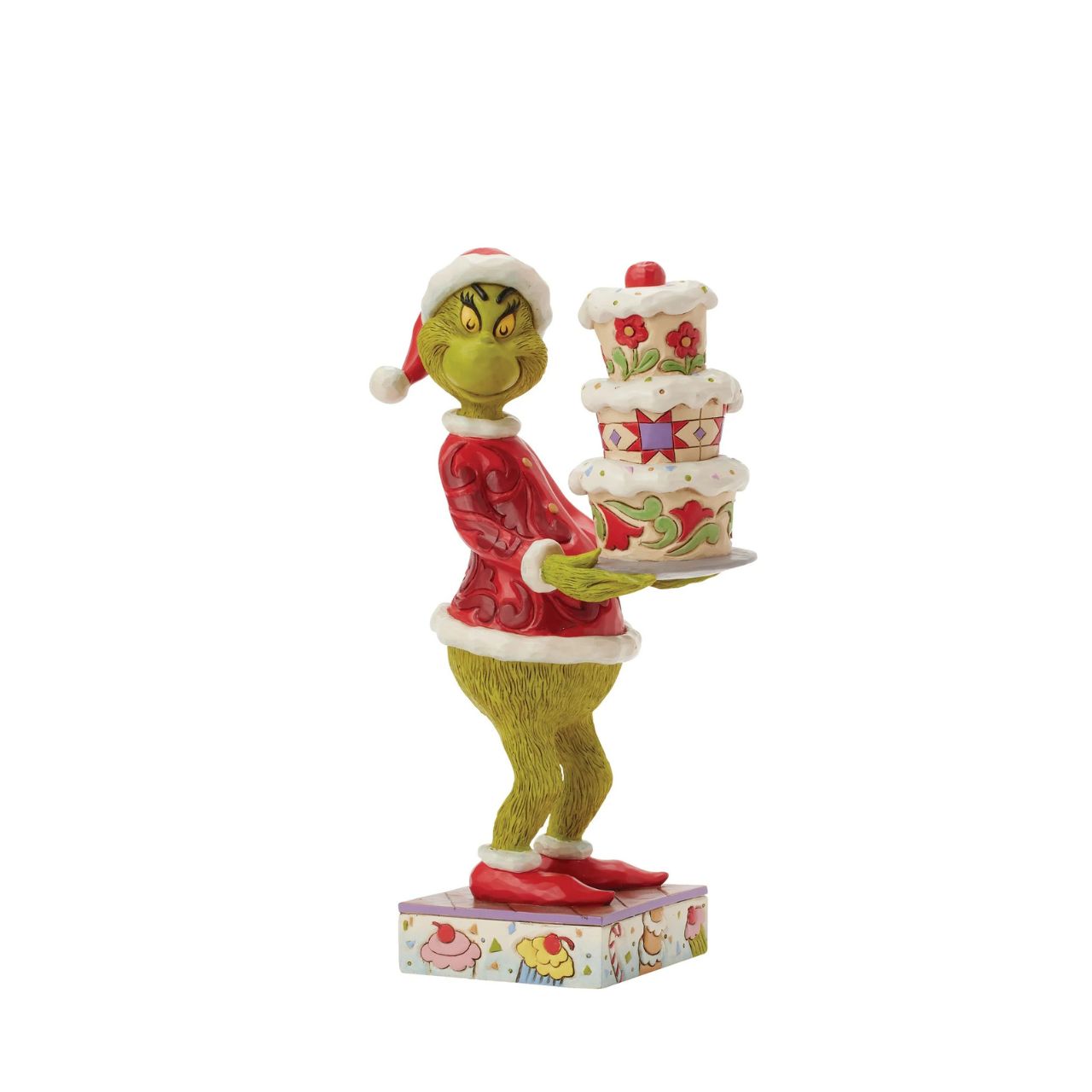 Disguised as Santa, The Grinch beams with trickery as he steals a towering cake. Adorned with Jim Shore's iconic rosemaling, patchwork patterns, and charming floral details, this piece captures the mischief of Christmas in true Grinch fashion.