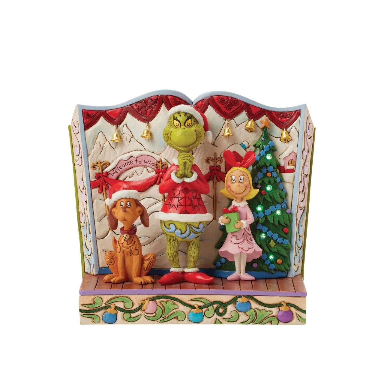 Framed within the classic Dr. Seuss book, this Jim Shore piece captures The Grinch's heartwarming transformation with Cindy Lou and Max by his side. Dressed as Santa, he smiles with rosemaling, patchwork patterns, and real jingle bell details.