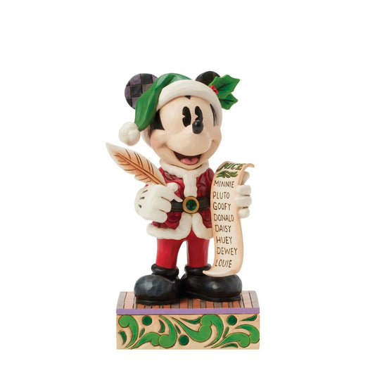 In this enchanting Jim Shore Christmas scene, Mickey Mouse dons a striking red rosemaling suit accented with a green jewelled belt and a Santa hat trimmed with holly. He holds a quill and a list of Naughty and Nice Disney characters with a smile.