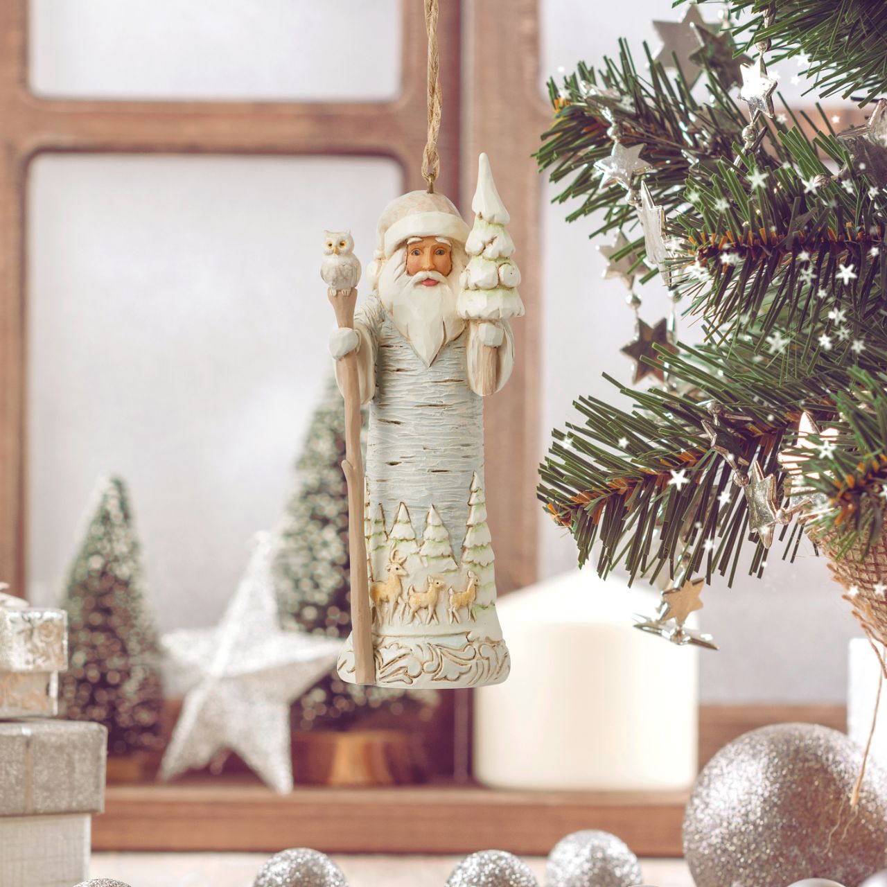 From the White Woodland collection as part of Heartwood Creek by Jim Shore, this Santa hanging ornament is created to look like he is carved from silver birch wood, a fun and creative way to bring the outside in this Christmas.