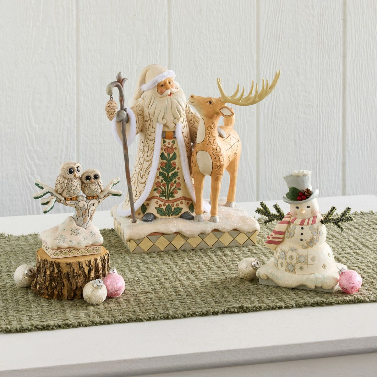 Celebrate the magic of Christmas with the Woodland Santa with Buck figurine from the Heartwood Creek collection by Jim Shore. This delightful figurine portrays Santa Claus in a heartwarming scene with a majestic buck, embodying the serene beauty of a winter forest.