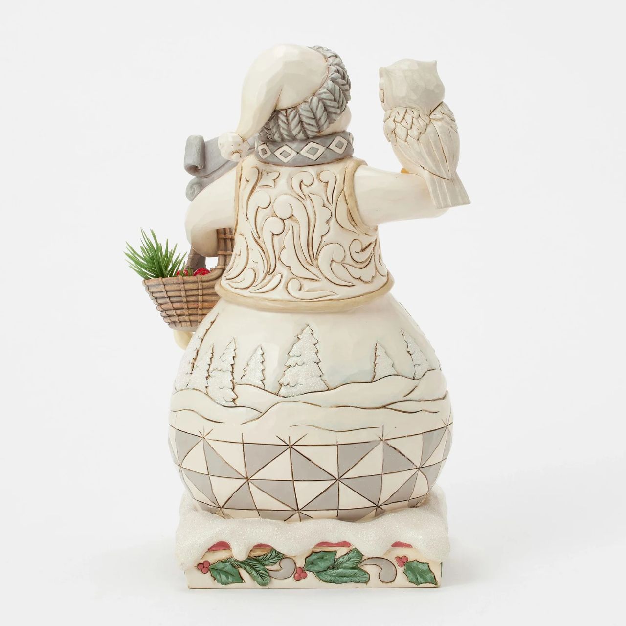 This enchanting Jim Shore White Woodland design features a charming snowman collecting evergreen sprigs in a basket, accompanied by a wise owl and a rabbit as he strolls through the serene forest. A deer scene is showcased on beneath his regal vest.