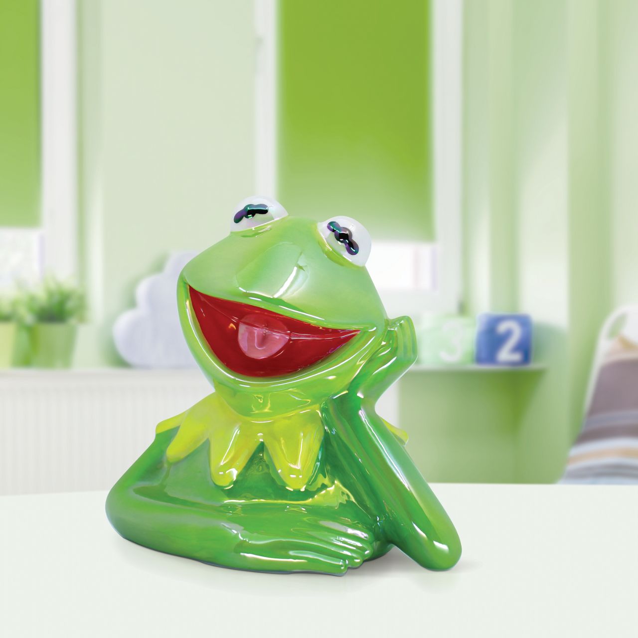 Make saving fun with the Kermit Ceramic Money Bank by Disney Showcase. It is the perfect, practical décor piece for Disney fans of all ages. At 15cm tall with a dazzling green, iridescent finish this piece is guaranteed to catch the attention of all that see it and will add the Disney magic to any home.