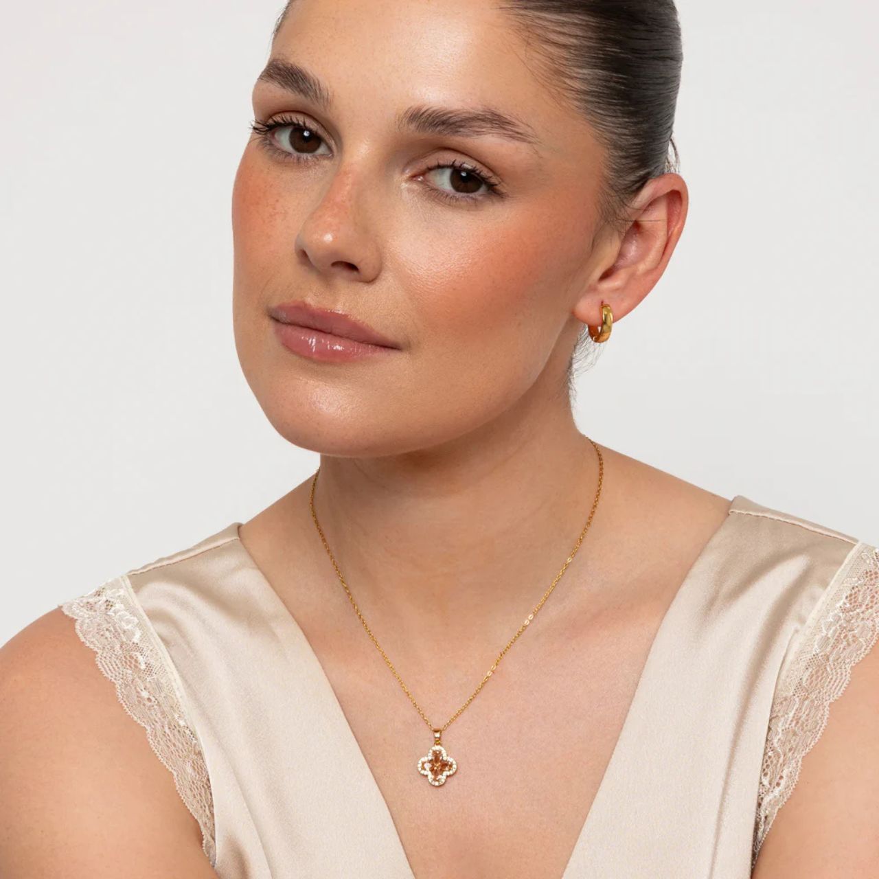 Elevate your elegance with the Knight and Day Champagne Clover Pendant, featuring delicately arranged champagne crystals in a refined clover design.