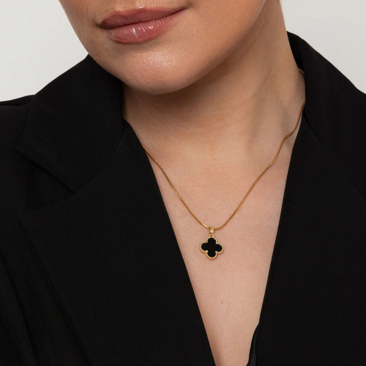 This elegant necklace from Knight and Day features a timeless clover pendant with a sleek black resin front and sparkling crystals on the reverse.