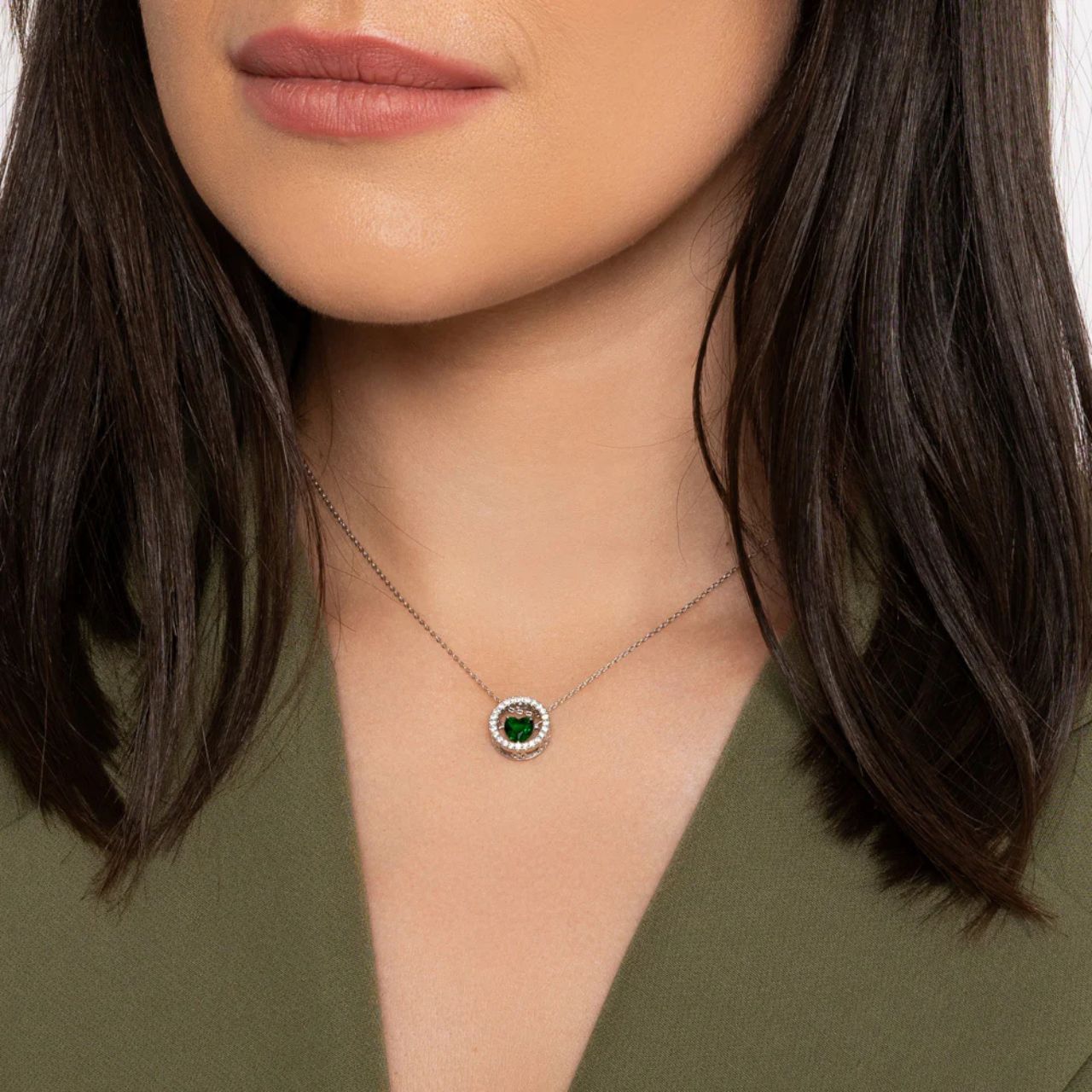 Beautiful emerald heart suspended on axis within crystal encrusted ring.
