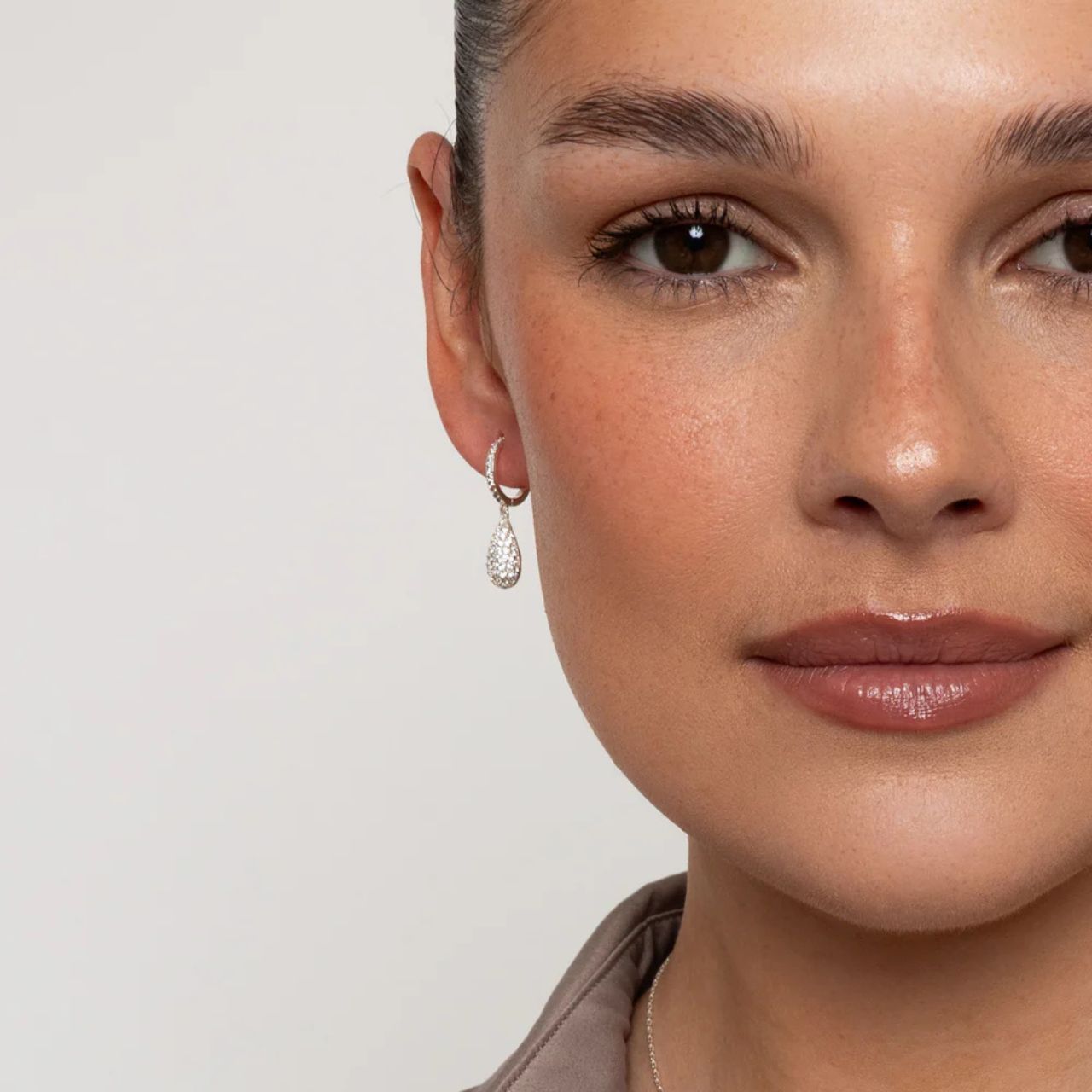 Beautiful teardrop earrings on miniature hoops, richly encrusted with CZ stones. Silver plating.