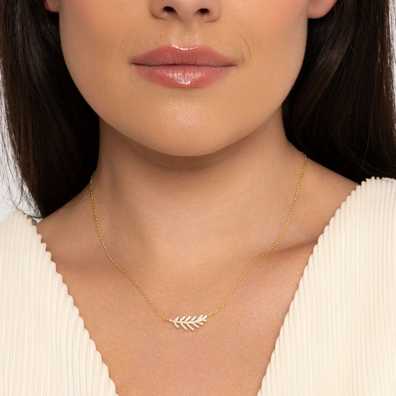 Elegant leaf pendant embellished with CZ stones in micro pavé setting. Gold plating. Length 16" + 2" extension.