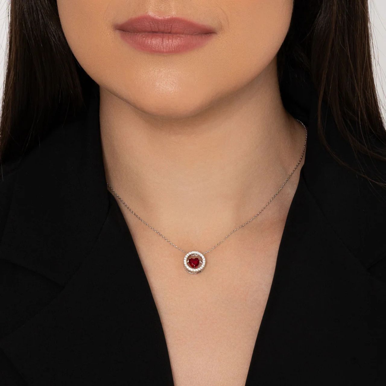 Beautiful siam red heart suspended on axis within crystal encrusted ring.