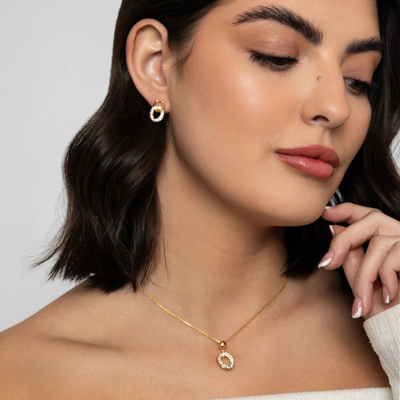 Miniature interlinking drops with CZ sparkle and 18K gold plating. Post fastening.