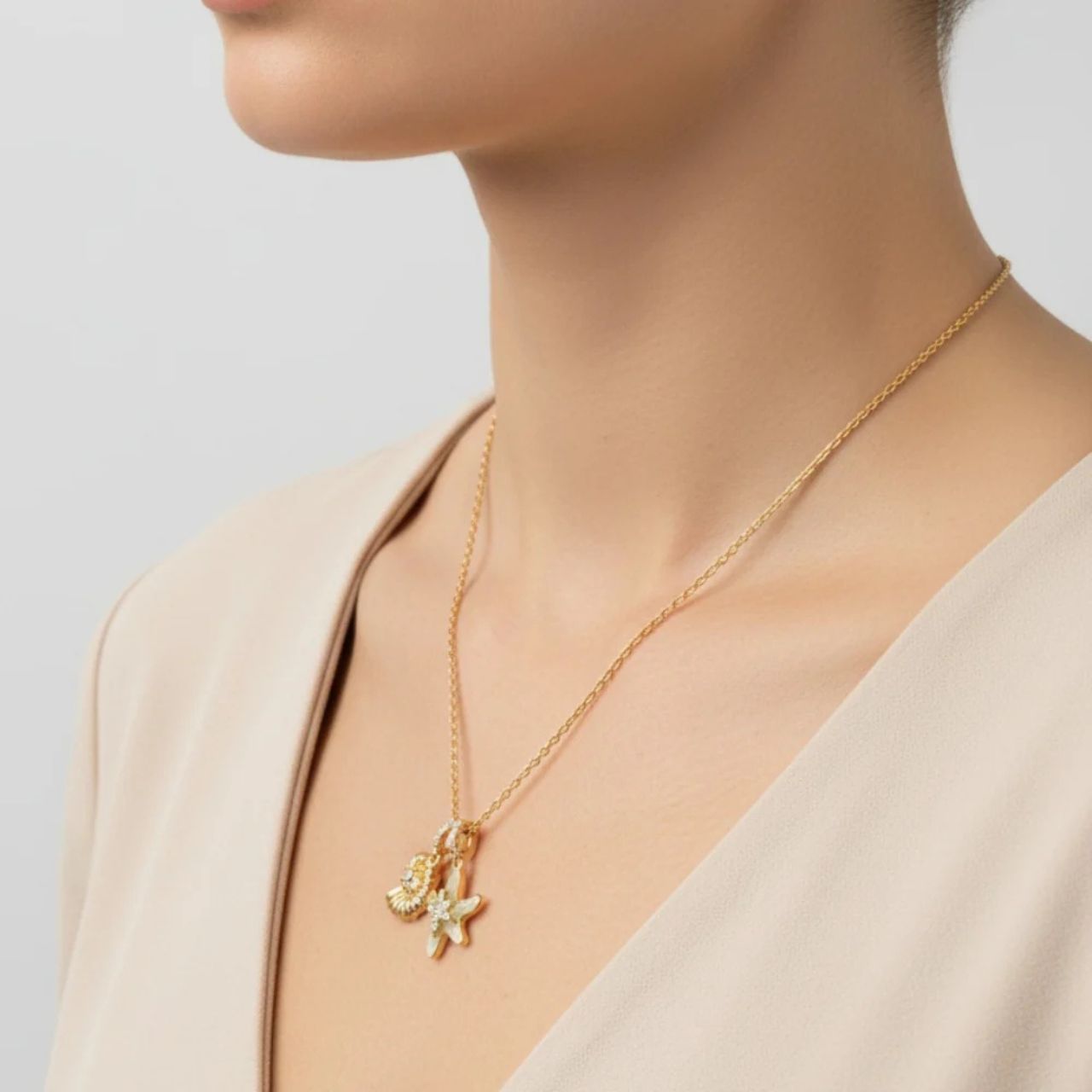 Pretty & delicate, this pendant combines starfish & shell charms embellished with green aventurine & crystal. Length 40 + 5cm extension. 18k gold plated.