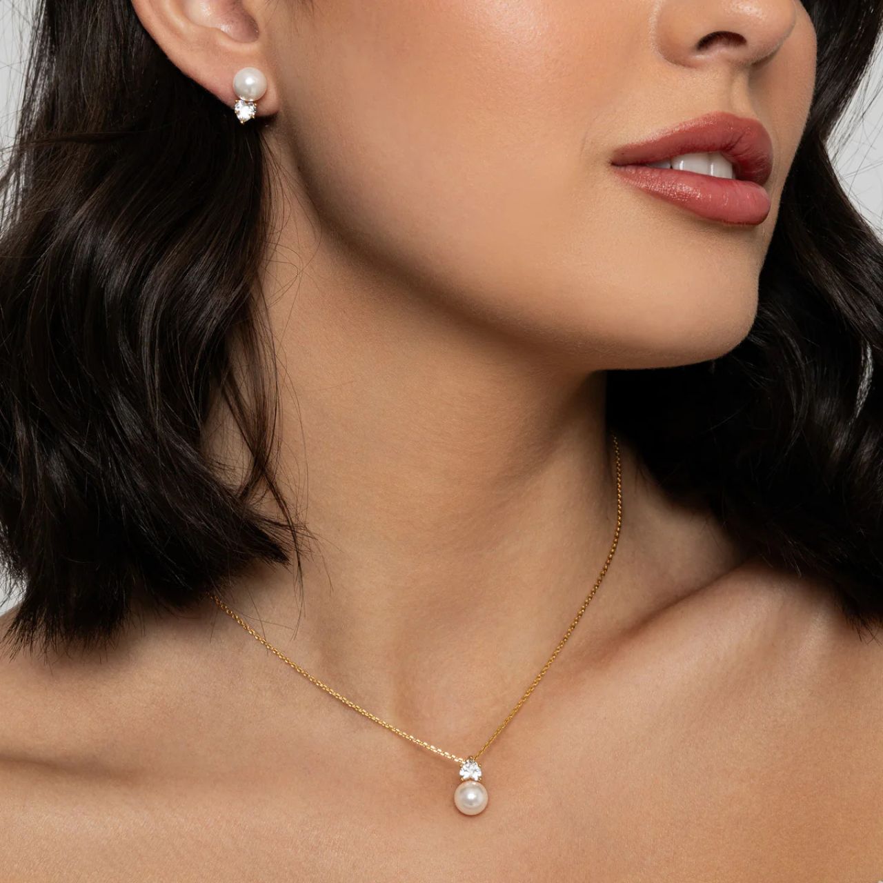Beautiful faux pearl with heart shaped CZ stone in matching earring & necklace set. 18K gold plating. Length 16" + 2" extension.