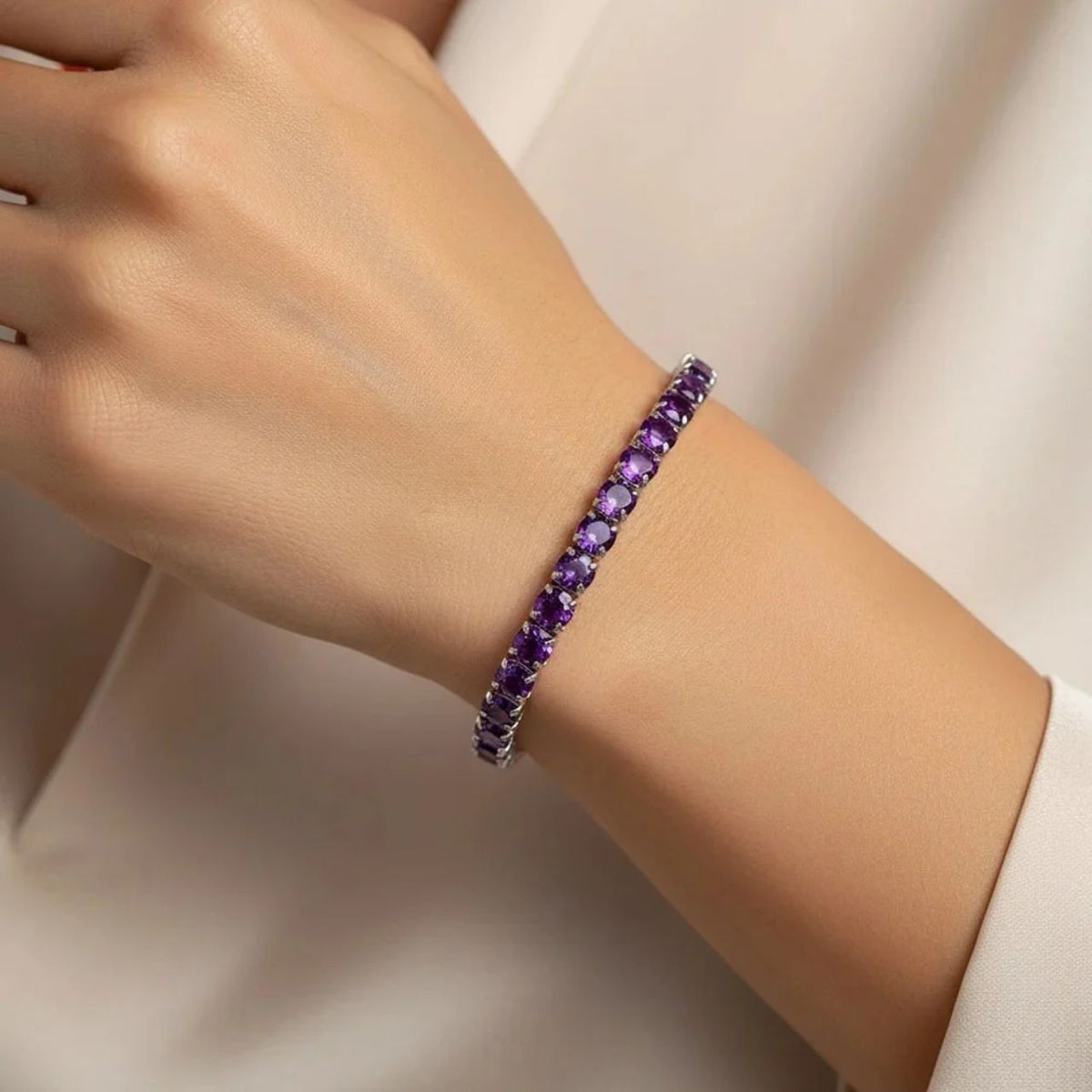 Knight & Day Amethyst Tennis Bracelet features stunning 4mm Amethyst CZ stones set in rhodium-plated silver. The medium-sized design showcases brilliant purple gemstones with a secure fold-over clasp for everyday wear or special occasions. An elegant addition to any jewelry collection.