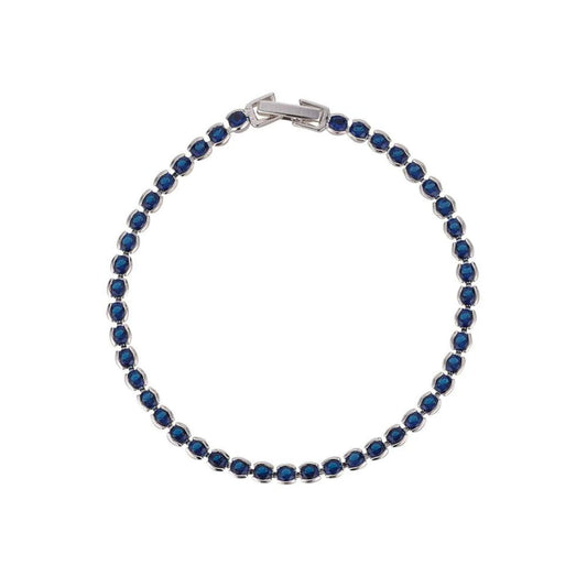Dakota Sapphire Tennis Bracelet by Knight & Day  Miniature rhodium plated tennis bracelet with Sapphire CZ stones. Elegant when worn alone and ideal for layering with watch or other bracelets. Fold over clip fastening.