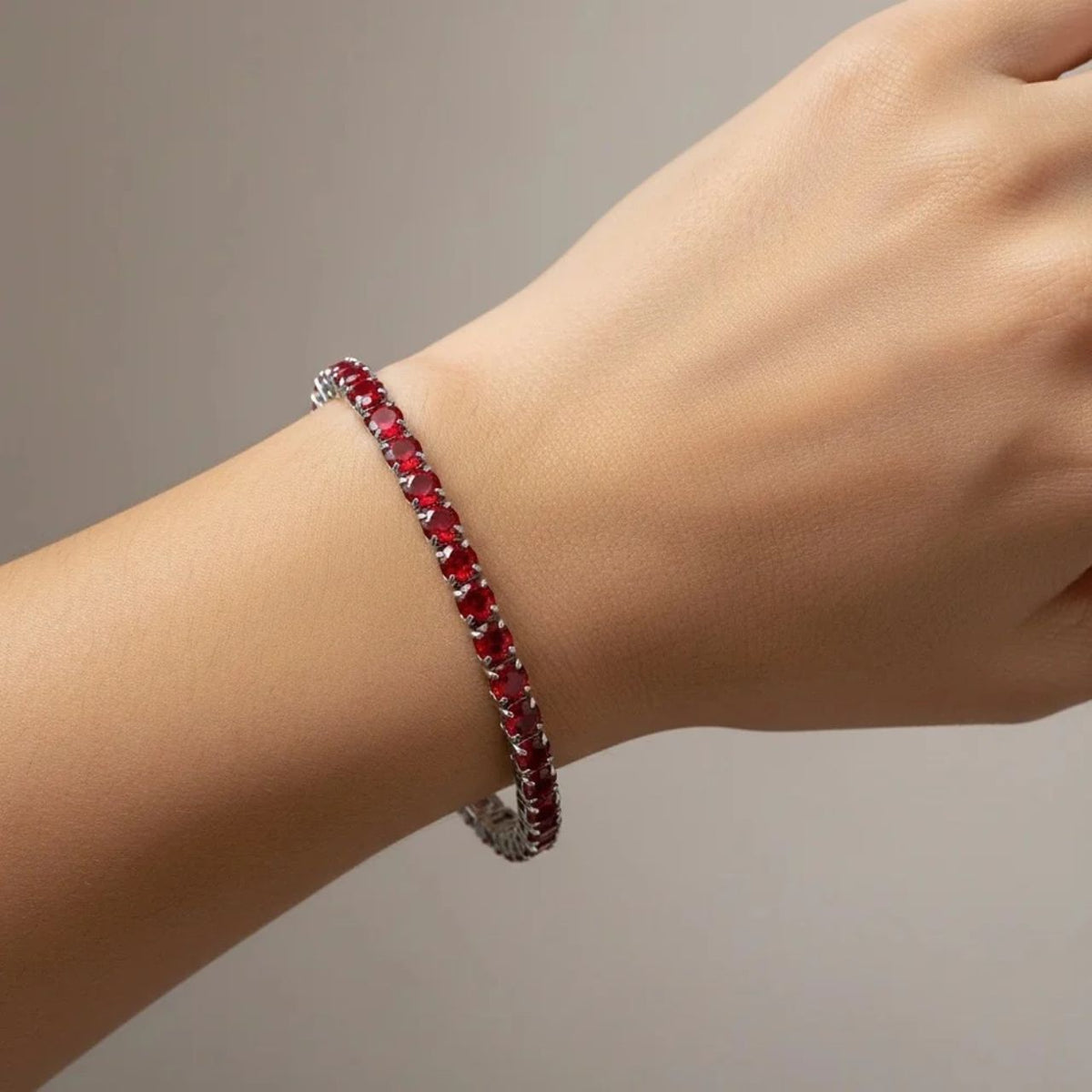 Beautiful tennis bracelet featuring 4mm garnet cubic zirconia stones set in rhodium-plated silver. The secure fold-over clasp ensures your bracelet stays fastened throughout the day, making it perfect for both everyday wear and special occasions. Classic design with timeless appeal.