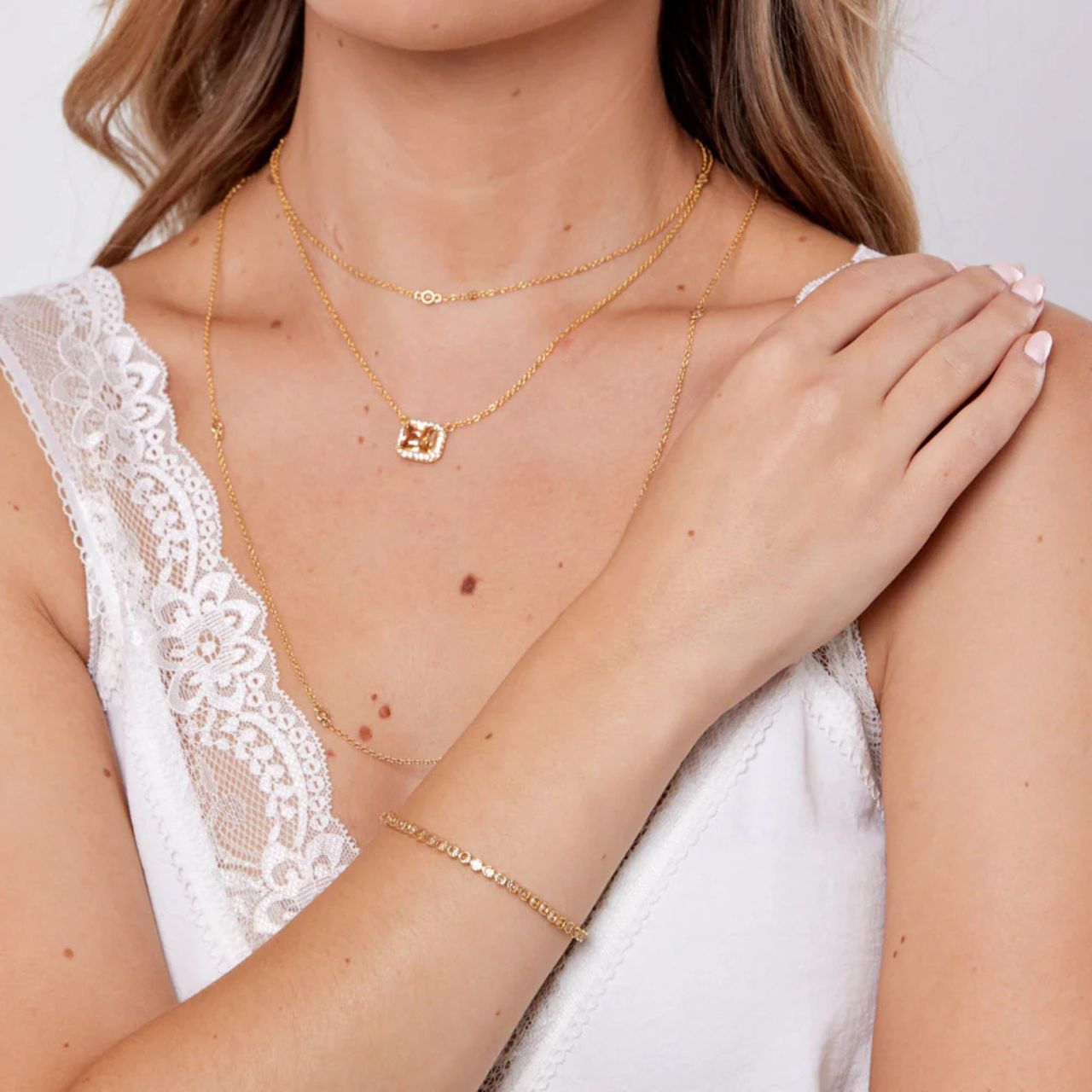 Miniature gold plated tennis bracelet with Champagne CZ stones. Elegant when worn alone and ideal for layering with watch or other bracelets.