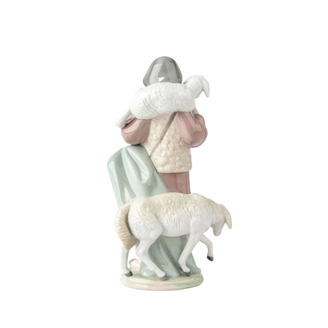 A young shepherd comes to worship the newborn Child Jesus, with a lamb on his shoulders and another close to his legs. It is part of a group of pieces that form a complete Nativity scene, the most important scene for all Christians in the world. It is a glossy porcelain piece decorated with Lladró's classic pastel color palette, a set designed to create a warm and welcoming atmosphere in the home during the family days of Christmas.