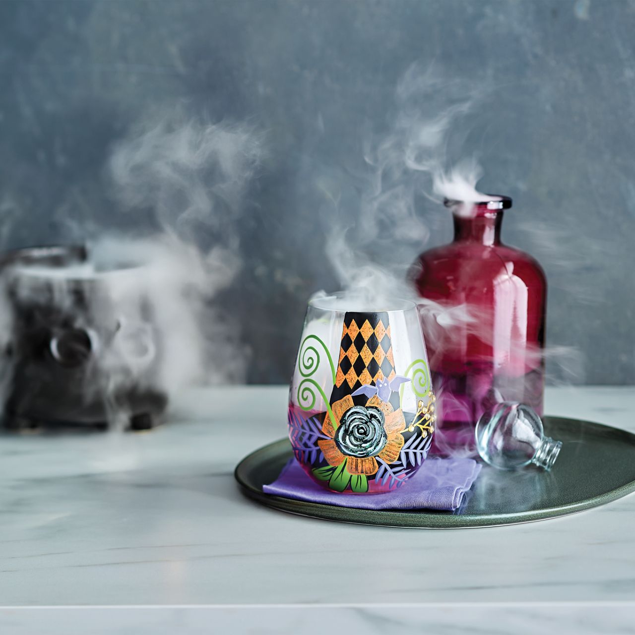 You'll be the talk of the coven when you're serving your creepy concoctions in the My Fancy Witch Hat Stemless Glass by Lolita. The hand-painted design features a witches hat, purple bat and shimmering rose, accentuated of course with Lolita's trademark sparkle.