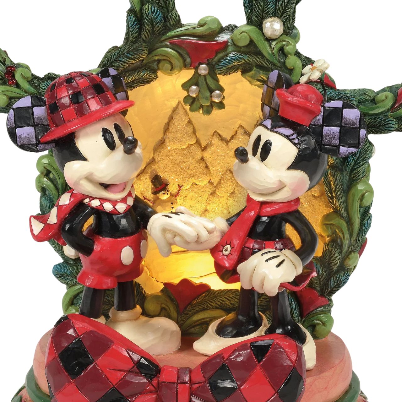 This delightful Jim Shore Christmas scene captures Mickey and Minnie holding hands beneath a glowing LED diorama, framed by a festive Mickey-shaped garland adorned with berries and pearl accents. It radiates seasonal magic with holiday charm.