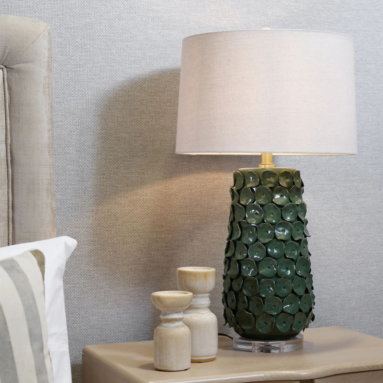 Illuminate your space with our Marin Lamp, featuring a simple shade and a base adorned with a circular pattern reminiscent of lily pods. Deep green in colour.