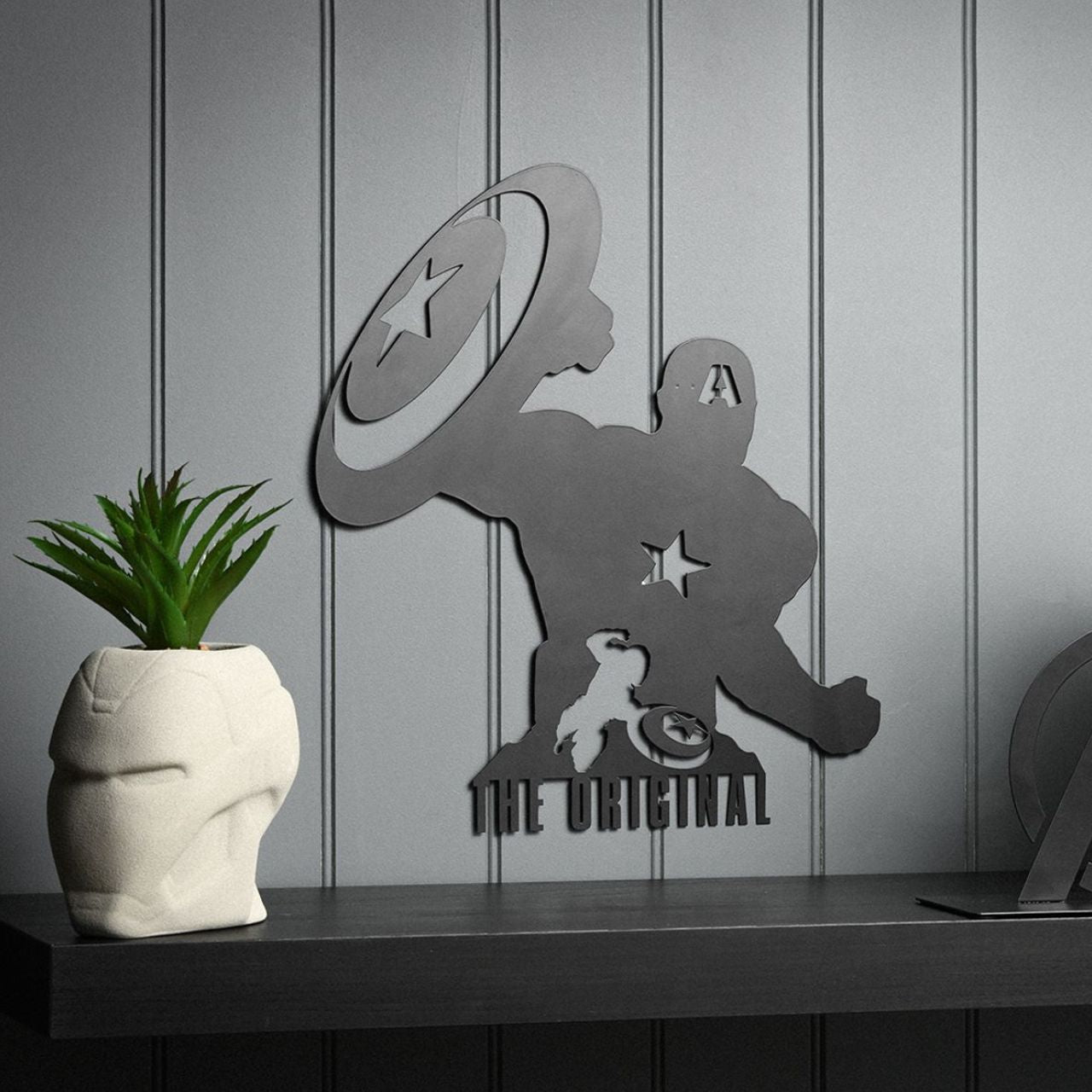 Infuse your space with a touch of superhero allure with our Marvel The Avengers Captain America Wall Plaque. This striking piece features a silhouetted figure holding a star-emblazoned shield, beneath the bold declaration: "THE ORIGINAL".